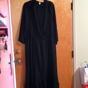 Black long sleeve dress with a split of ruffles on the front  a shire material
